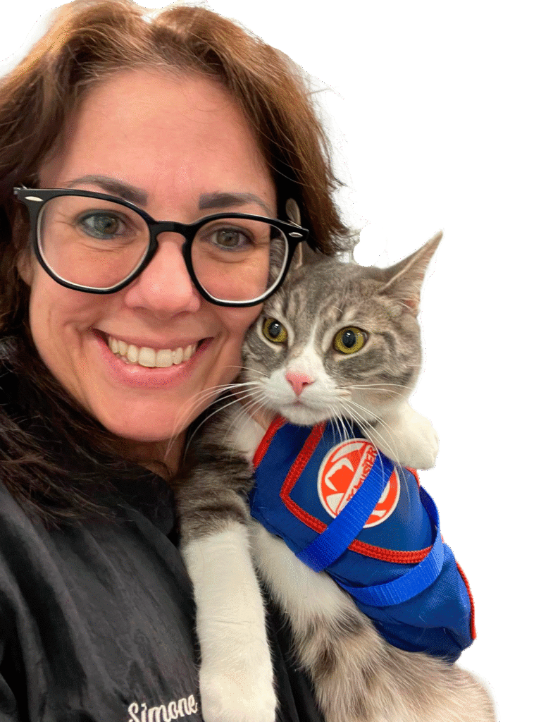 Simone, a cat sitter, holds a cat and smiles