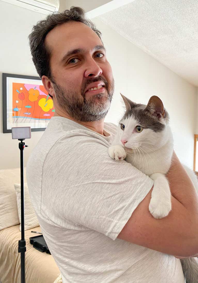Felipe holds a grey and white cat