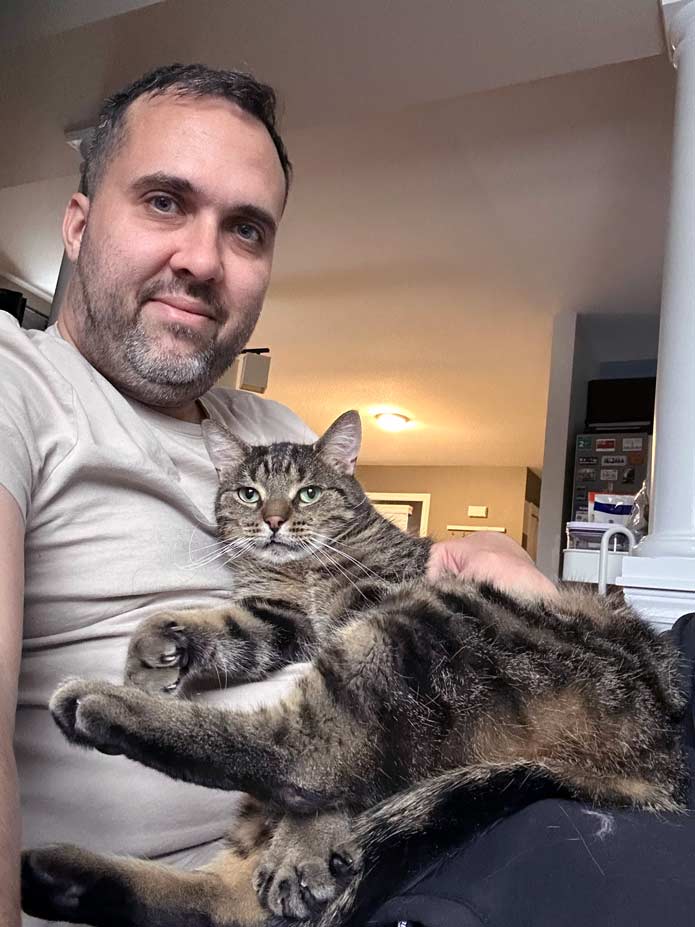 Felipe pets a cat named Kiwi