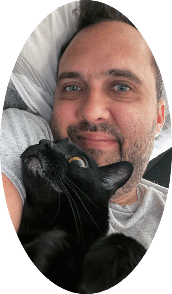 Felipe sitting his cat Bono at home in London, Ontario