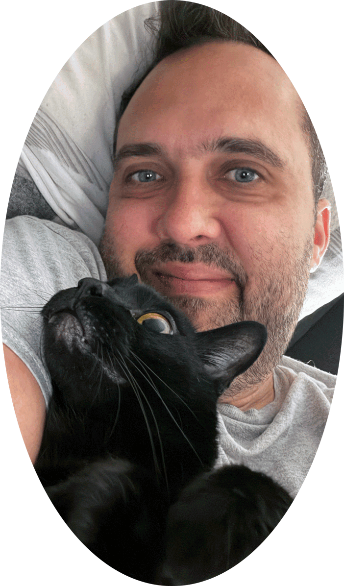 Felipe sitting his cat Bono at home in London, Ontario