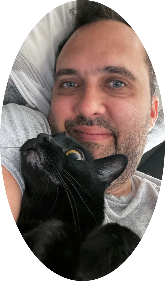Felipe sitting his cat Bono at home in London, Ontario